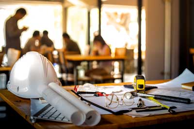 Paper, glasses, hammer, keyboard and tape measure on a table